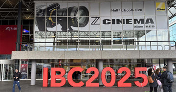 IBC 2025 entrance featuring a Nikon camera banner promoting COMAN snap-open camera tripod and M1 monopods.
